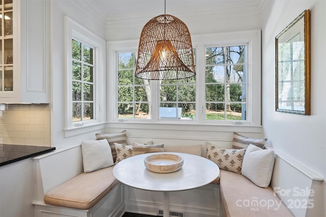 dining area featuring breakfast area, a wealth of natural light, and ornamental molding