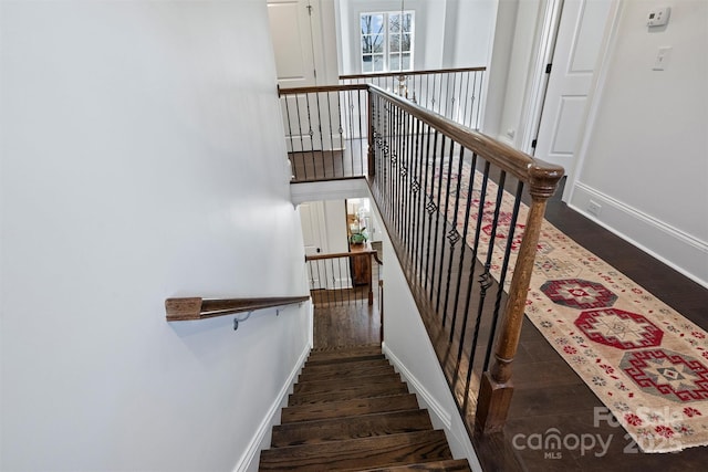 staircase with baseboards and wood finished floors