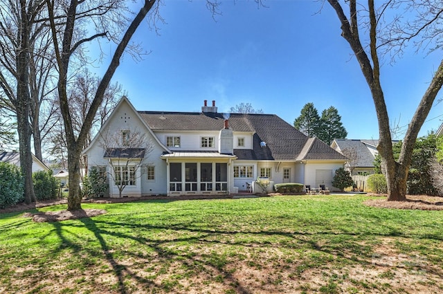 rear view of house featuring a sunroom, a lawn, and a patio