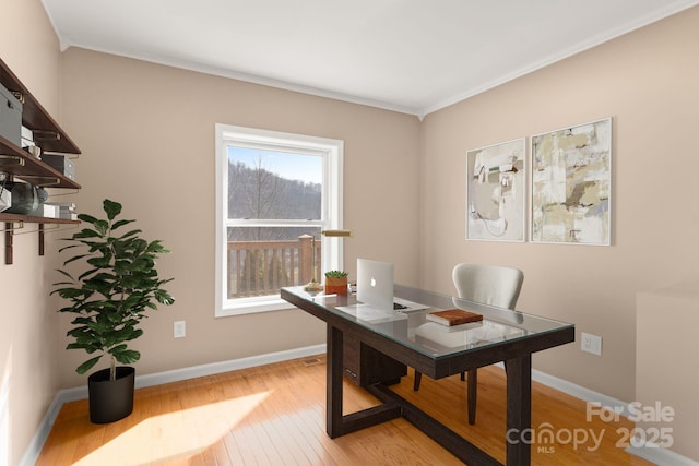 office area featuring crown molding, light wood finished floors, and baseboards