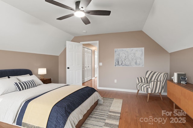 bedroom featuring vaulted ceiling, wood finished floors, a ceiling fan, and baseboards