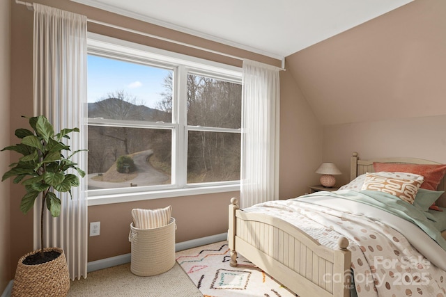 carpeted bedroom with baseboards and vaulted ceiling