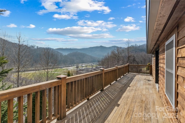 deck featuring a mountain view and a view of trees