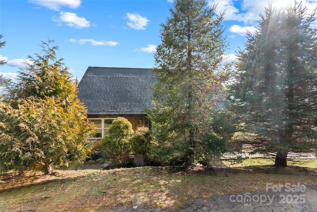 view of side of property featuring a shingled roof