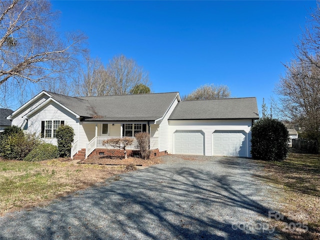 ranch-style home with a garage, covered porch, and gravel driveway