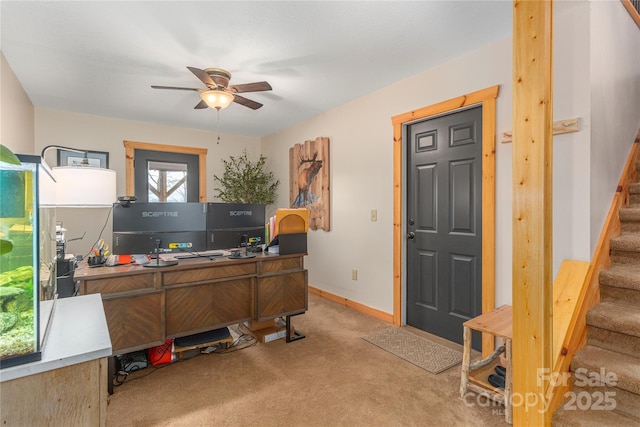 carpeted home office with ceiling fan and baseboards