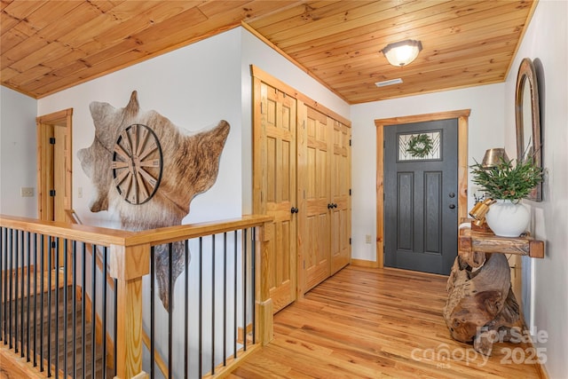 entryway featuring light wood finished floors and wood ceiling