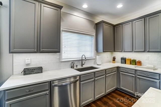 kitchen with dark wood-type flooring, dishwasher, backsplash, and a sink