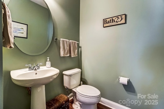 half bath with toilet and baseboards