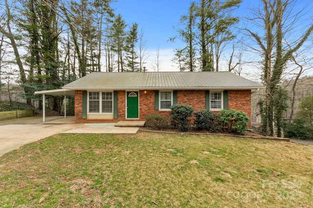 ranch-style home featuring brick siding, a front lawn, metal roof, a carport, and driveway