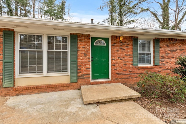 doorway to property with brick siding