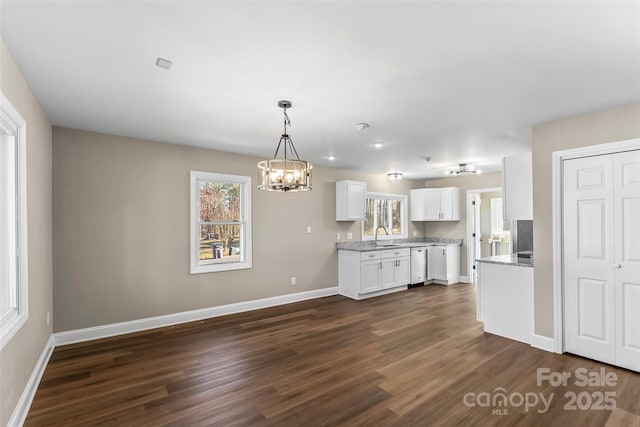 kitchen with white cabinets, dishwasher, a notable chandelier, and dark wood-type flooring