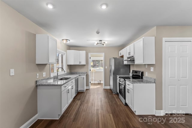 kitchen with light stone countertops, baseboards, under cabinet range hood, a sink, and stainless steel appliances