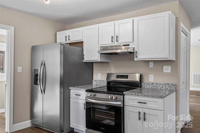 kitchen with dark wood-style floors, white cabinetry, under cabinet range hood, light stone counters, and appliances with stainless steel finishes