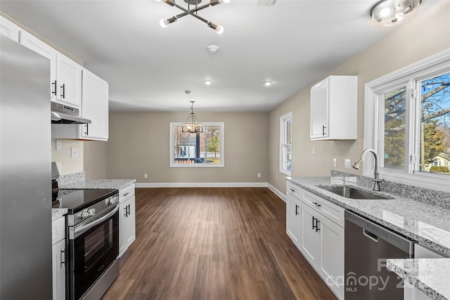 kitchen featuring a sink, appliances with stainless steel finishes, dark wood finished floors, and a chandelier