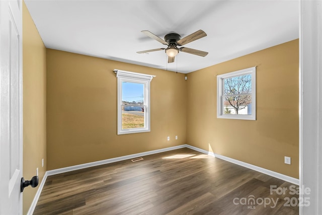 spare room featuring a ceiling fan, baseboards, and wood finished floors