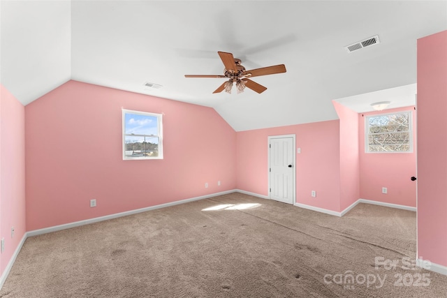 bonus room with vaulted ceiling, ceiling fan, carpet flooring, and visible vents