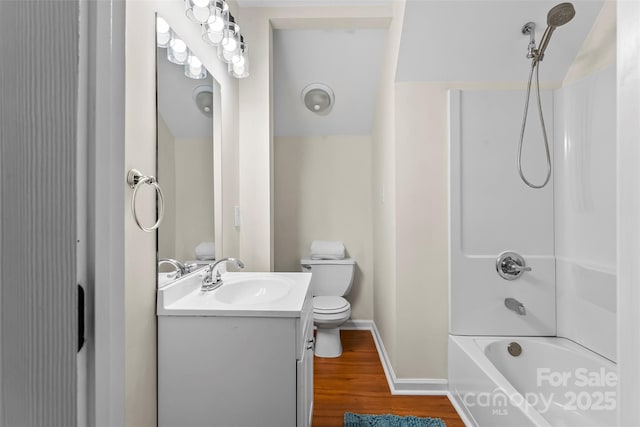 full bath with vanity, wood finished floors, toilet, baseboards, and shower / bath combination