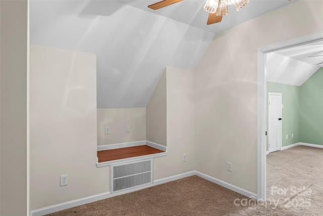 additional living space with carpet flooring, a ceiling fan, baseboards, and vaulted ceiling