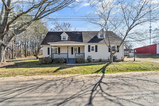 new england style home featuring roof with shingles, covered porch, crawl space, and a front yard