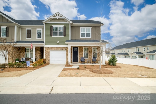 view of front of property featuring a porch, an attached garage, fence, concrete driveway, and board and batten siding