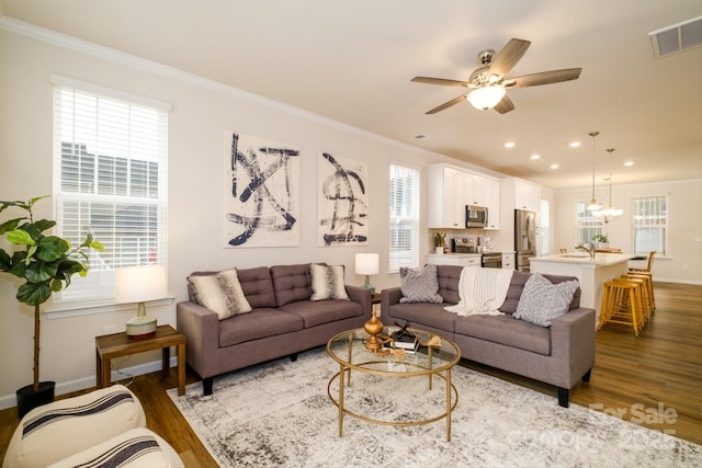 living room with ornamental molding, dark wood-type flooring, and visible vents