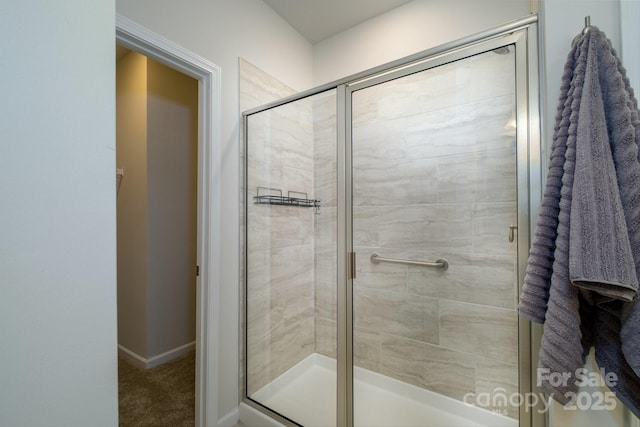 bathroom with a stall shower and baseboards