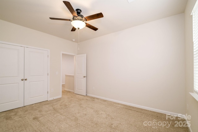 unfurnished bedroom with carpet floors, a closet, ceiling fan, and baseboards