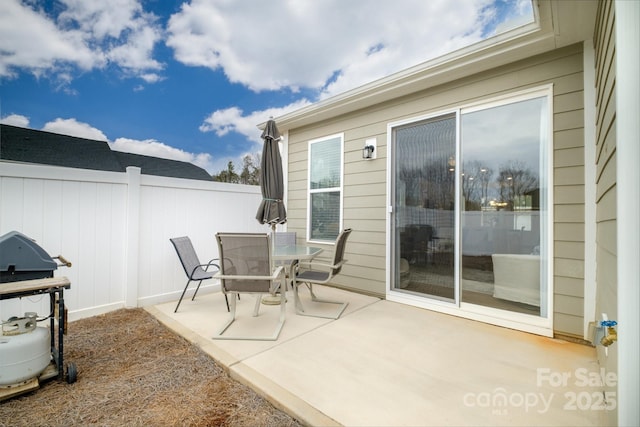 view of patio / terrace with a grill, fence, and outdoor dining space