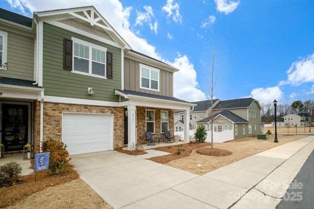 view of front of home with a porch, board and batten siding, a garage, a residential view, and driveway