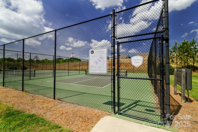 view of sport court featuring fence and a gate