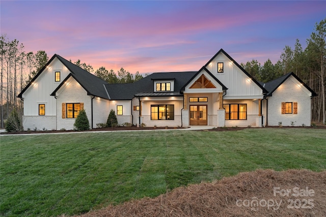 modern inspired farmhouse featuring a standing seam roof, metal roof, board and batten siding, and a yard