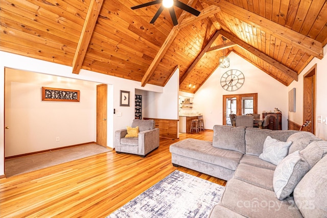 living area featuring wood finished floors, high vaulted ceiling, beam ceiling, ceiling fan, and wooden ceiling