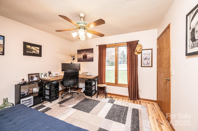 bedroom with baseboards, a textured ceiling, wood finished floors, and a ceiling fan