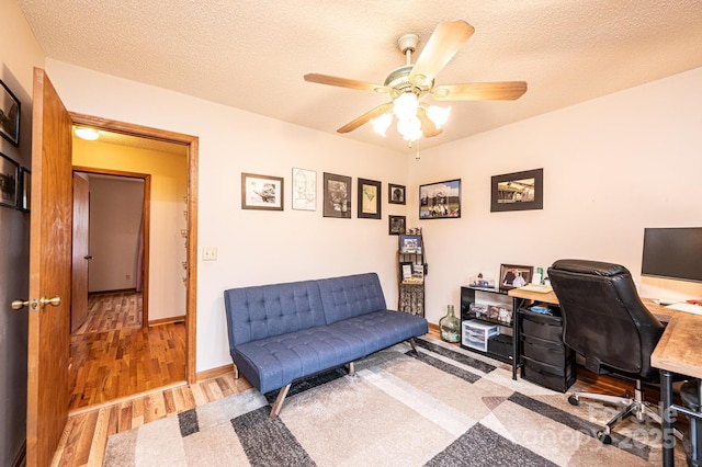 office area with baseboards, a textured ceiling, ceiling fan, and wood finished floors