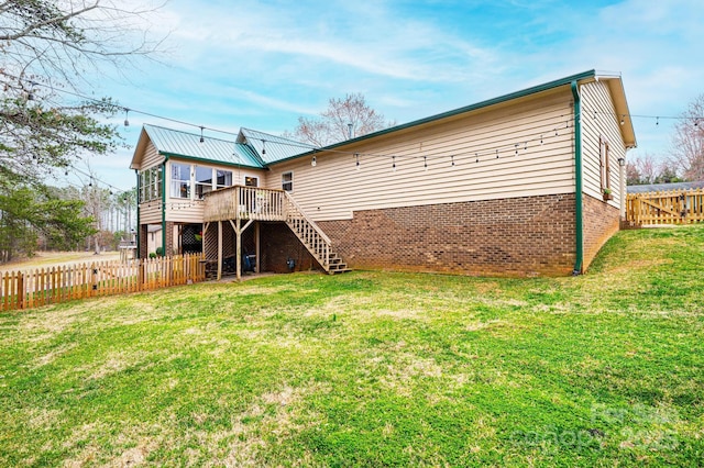 back of house featuring a wooden deck, a lawn, a fenced backyard, and stairs