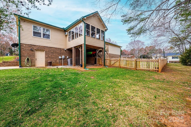 back of property featuring a gate, fence, a yard, central air condition unit, and brick siding