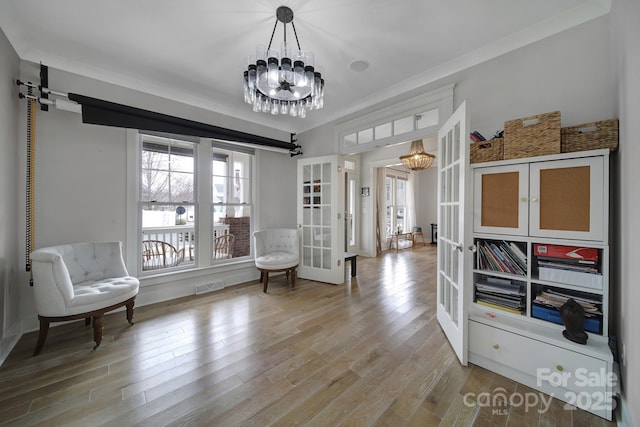 living area with light wood-type flooring, french doors, visible vents, and a notable chandelier