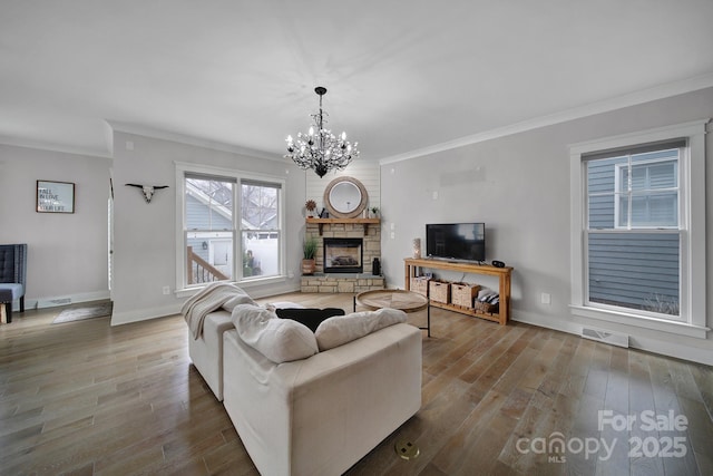 living area featuring crown molding, visible vents, a chandelier, and wood finished floors