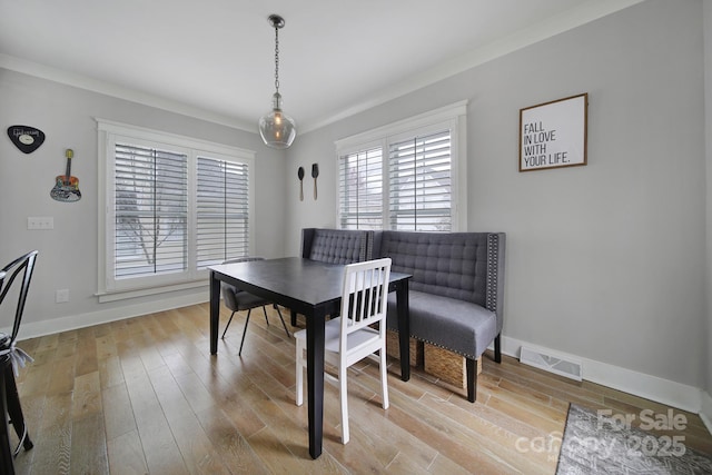 dining room featuring light wood-type flooring, baseboards, and visible vents