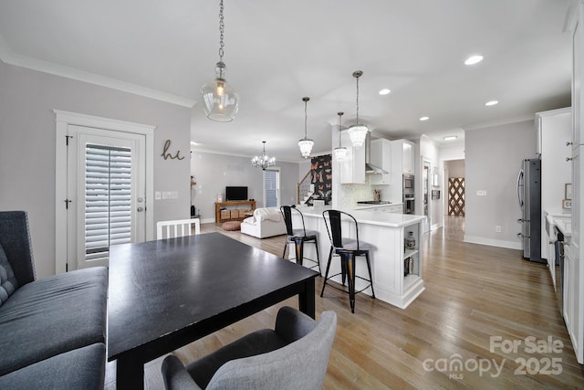 dining room featuring ornamental molding, recessed lighting, light wood-style flooring, and baseboards