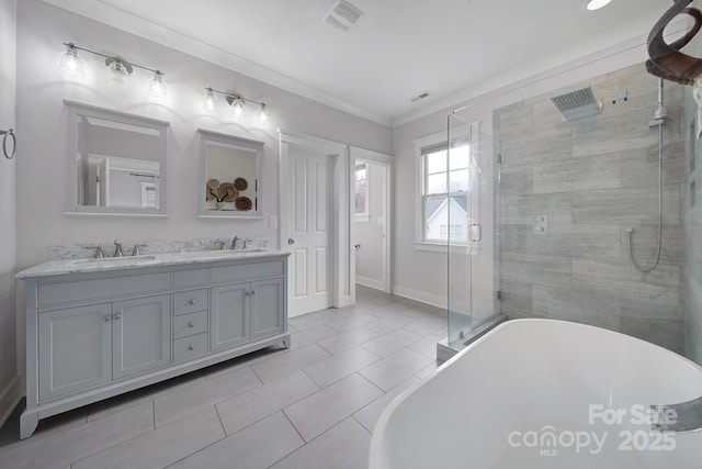 bathroom featuring double vanity, visible vents, a stall shower, a sink, and a freestanding tub