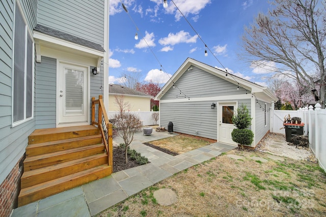 exterior space with a patio area, a fenced backyard, and an outbuilding