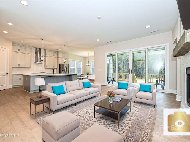 living area featuring light wood-style floors, a fireplace, and recessed lighting