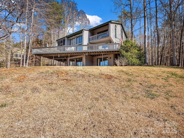 back of house with a lawn and a deck