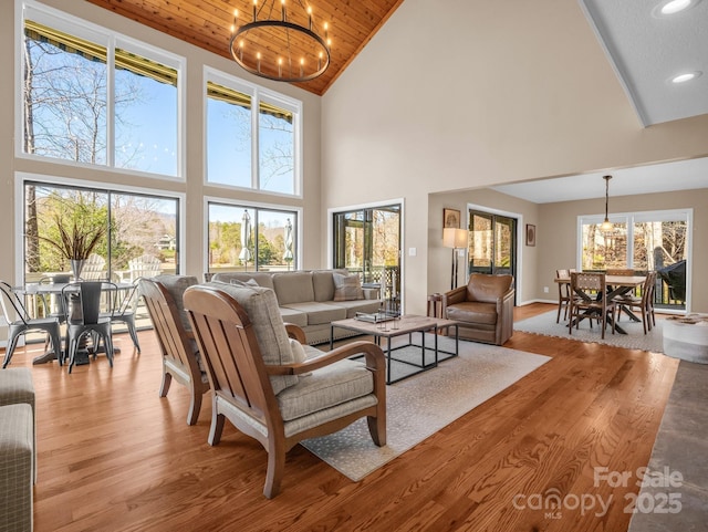 living room featuring recessed lighting, an inviting chandelier, light wood-style flooring, and wooden ceiling