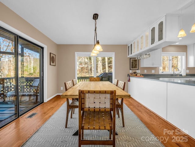 dining area featuring baseboards, visible vents, and light wood-type flooring