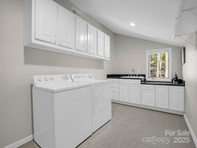 laundry area with baseboards, visible vents, washing machine and clothes dryer, cabinet space, and a sink