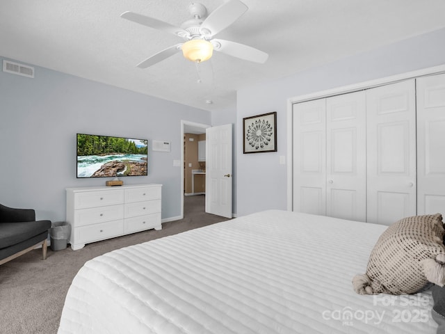 carpeted bedroom featuring a closet, visible vents, and a ceiling fan