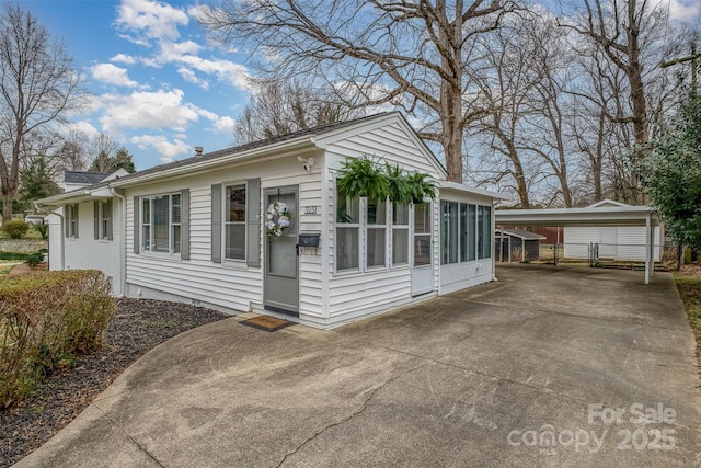 view of front of home with a detached carport and concrete driveway